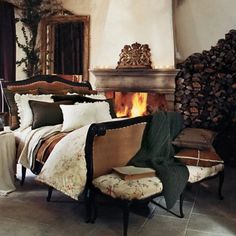 a bed sitting next to a fire place in a bedroom on top of a stone floor