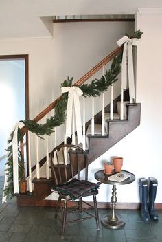 the stairs are decorated with garland and pine cones