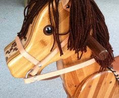 a wooden toy horse with dreadlocks on it's head