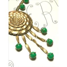 This is part of Chairish’s Costume Jewelry assortment.  Vintage Gold Green Statement Necklace 1970s Sunflower Dangles Beads  ------------------  Stylish gold necklace with beautiful green round beads...the middle pendant is a sunflower design...multiple green beads at the chain plus 5 dangles each ending with that same green bead encased in gold...secure closure.  Overall length of chain: 18"   Plus total pendant drop: 5.50" Green Dangle Jewelry With Large Beads, Green Costume Jewelry Beaded Necklace, Green Beaded Necklace With Round Pendant, Green Round Jewelry With Dangling Beads, Handmade Retro Green Jewelry, Unique Green Dangle Beaded Necklaces, Vintage Green Beaded Chain Jewelry, Vintage Green Dangle Necklaces, Vintage Green Pendant Beaded Necklace