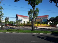 a yellow car is parked on the side of the road in front of a building