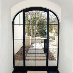 an arched glass door leading to a patio with black and white tiles on the floor