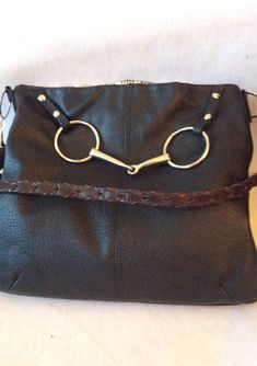 "One in stock This Leather Handbag Equestrian Horse Purse with a Horse bit was first introduced to my collection in 2019 . It combines quality leather and a total equestrian look making this your go to bag. The leather is soft and supple yet sturdy enough to be tossed in the car or your tack trunk. Pictured is an equestrian print with side saddle ladies. You can choose another fabric to truly make it your own. Prices of lining fabric will vary depending on your choice. It has one zip pocket and Travel Shoulder Bag With Horsebit Detail, Black Rectangular Bag With Horsebit Detail, Black Shoulder Bag With Horsebit Detail, Black Shoulder Bag With Horsebit Detail For Travel, Rectangular Bags With Horsebit Detail For Everyday Use, Black Leather Bag With Horsebit Detail, Rectangular Shoulder Bag With Horsebit Detail For Everyday Use, Everyday Crossbody Bag With Horsebit Detail, Travel Satchel Shoulder Bag With Horsebit Detail