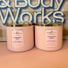 two pink candles sitting next to each other on a table