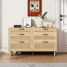 a wooden dresser sitting in front of a door with a painting on the wall above it