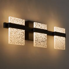 three square lights are mounted on the wall