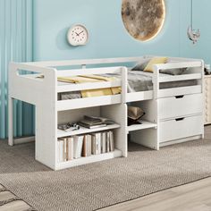 a white bed with drawers underneath it and a clock hanging on the wall above it