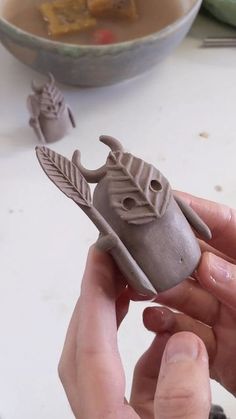 a person is holding a clay object in their hand and it looks like they are making something out of clay