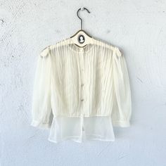 "S p e c i f i c s . . . Label: Paulwin Tagged Size: -- Approx Fit: XS - S Color: White Material: Nylone Sheer Material // Buttons  Condition: Overall in Amazing Vintage Condition M e a s u r e m e n t s . . . (side to side // laying flat // closed) Bust - approx. up to 21\" Waist - approx. 14\" Length - approx. 22\"" Summer Button-up Top With Sheer Sleeves, Chic Vintage Summer Tops, Chic Fitted Tops For Vintage Fashion, Vintage Long Sleeve Sheer Tops, Vintage Sheer Blouse For Spring, Chic Vintage Spring Tops, Vintage Long Sleeve Sheer Blouse, Vintage Spring Party Shirt, Vintage Sheer Long Sleeve Blouse