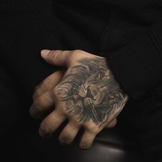 a man's hand with a lion tattoo on it