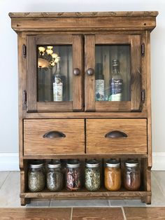 an old wooden cabinet with spice jars on it