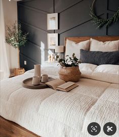 a bed with white linens, pillows and a basket on it's headboard