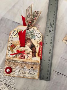 an altered christmas tag next to a ruler