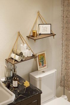 a bathroom with two shelves above the toilet