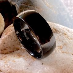 a black ring sitting on top of a rock