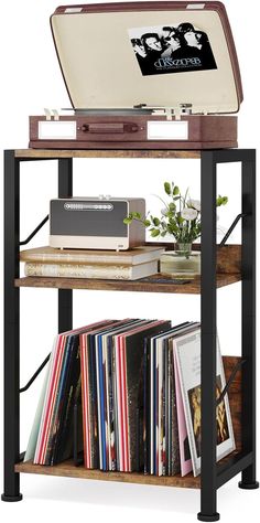 an old record player is sitting on top of a shelf with books and cds in it