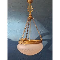 an antique chandelier hanging from the ceiling in a room with blue wallpaper