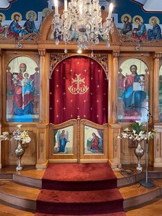 an ornate church with paintings on the walls and red carpeted steps leading up to it