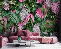 a living room with pink couches and green plants on the wall