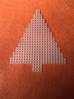 a white cross stitched christmas tree on an orange background