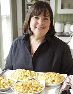 a woman is holding two trays of food