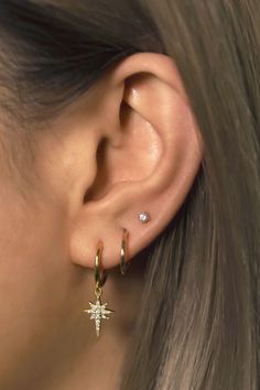 a close up of a person's ear with two small stars attached to it