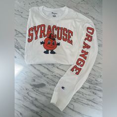 Nwot Syracuse University Long Sleeve Tshirt. Never Worn. In Excellent Condition. The College Mascot, Otto, Is Featured Prominently On The Front. Note “Orange” Runs Down The Left Sleeve. White Long Sleeve Graphic T-shirt, White Crew Neck Campus Style Top, White Long Sleeve Graphic Tee, White Cotton Sweatshirt With Text Print, White Long Sleeve School Spirit Shirt, White Pre-shrunk Cotton Sweatshirt, White Long Sleeve Shirt For School Spirit, White Cotton Pre-shrunk Sweatshirt, White Collegiate Graphic T-shirt