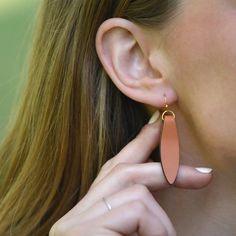 Our Brown Fold Over Leather Earrings earrings offer up modern style that's simple and eye catching. Each pair comes with 2 rubber earring backs (be sure to wear these with your earrings!) Leather is folded over a gold-fill finding, creating a petal shape.  This listing is for brown leather, this style is also available in black leather.Finishes + Details: Earrings are made from authentic leather. All findings are gold-fill.Dimensions: Earrings hang approximately 2-inches down.Country of Origin:E Modern Rose Gold Teardrop Earrings, Nickel-free Drop Earrings For Everyday, Adjustable Drop Earrings For Everyday Use, Dangle Earrings For Everyday Use, Everyday Adjustable Teardrop Earrings, Adjustable Drop Plug Earrings For Everyday Wear, Adjustable Teardrop Wrap Earring, Everyday Nickel-free Teardrop Wrap Earrings, Elegant Everyday Nickel-free Earrings