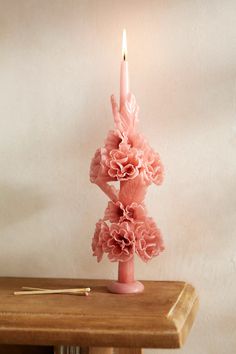 a pink candle sitting on top of a wooden table