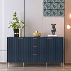 a sideboard with two vases on it and a plant in the corner next to it