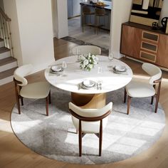 a dining room table with four chairs and a white centerpiece on top of it