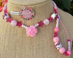 This beautiful pink beaded necklace set is perfect for adding a touch of girly glam to any outfit. The set includes a long necklace with a variety of pink beads, including pink glass beads, pink acrylic beads, and pink seed beads. A sparkling pink star charm and a delicate rose charm add a touch of whimsy to the design. The necklace is finished with a lobster clasp closure. The set also includes a shorter necklace with pink beads and a magnetic clasp closure. Adjustable Single Strand Pink Beaded Necklace, Pink Beaded Chain Jewelry For Gift, Adjustable Pink Necklace With Rose Design, Pink Bohemian Jewelry For Valentine's Day, Bohemian Pink Jewelry For Valentine's Day, Trendy Beaded Flower Necklace Gift, Handmade Adjustable Pink Necklace, Feminine Pink Flower Necklace For Gift, Cute Pink Flower Necklace For Gift