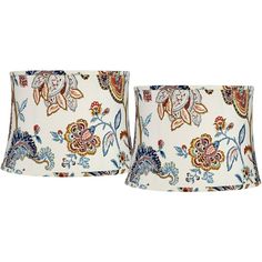 two lampshades with floral designs on them, one is white and the other is blue