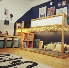 a bunk bed with a couch underneath it in a room that has blue walls and wooden floors