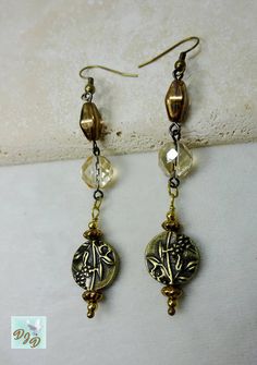 Handmade long Boho fun dangle earrings in lovely champagne, gold and bronze colors.  Great casual earrings featuring antique brass plated coin bead with an embossed floral design. A variety of Czech beads are used  including  champagne gold faceted rounds, roundels with a soft pearlized gold finish, and oval beads with a metallic bronze gleam.  The focal puffed coin beads are enhanced with brass beads and metallic bronze finish bead caps.   The earrings are about 3.25 inches long from to of the Antique Gold Metal Chandelier Earrings, Brass Dangle Earrings With Gold Beads, Vintage Gold Beaded Earrings, Bronze Dangling Beads Earrings For Gift, Bronze Beaded Dangle Earrings, Gold Beads Brass Dangle Earrings, Bronze Earrings With Dangling Beads For Gift, Antique Gold Copper Drop Earrings, Gold Earrings With Gold Beads