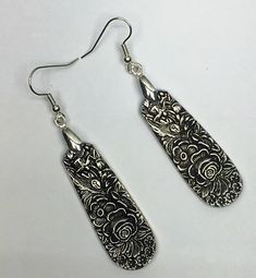 pair of silver earrings with intricate designs on them