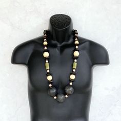 This long beaded necklace was handmade using a stylish mix of tribal beads including distressed black wooden rondelles, 25mm round beige wood beads, olive green ceramic tubes, a variety of small wooden brown beads, geometric beige wood beads, and three HUGE 40mm round distressed black wooden beads. An amazing one of a kind piece! The necklace measures 35 inches in length and is securely fastened with a sterling silver toggle clasp. Perfect for any gender! Length can be adjusted if needed - just Black Wooden Beads For Jewelry Making, Black Wooden Beads Necklace For Jewelry Making, Black Wooden Beads Bohemian Style, Handmade Black Earthy Jewelry, Black Bohemian Wooden Beads, Bohemian Black Wooden Beads, Rustic Wooden Beads, Rustic Round Wooden Beads, Artisan Black Beaded Necklaces With Wooden Beads