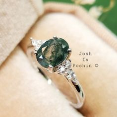 a close up of a ring with a green stone