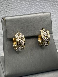 A gorgeous ladies pair of hoop earrings designed and crafted in 14 karat solid yellow and white gold.  The open scroll pattern adds dimension and unique beauty to this classic style.  They are perfect for any woman! Weight:  3.6 grams Diameter:  ⅝" Our Price $375.00 Regularly Priced At $600.00 Please See Our Video Remember - If you're purchasing for yourself or a gift for a loved one, buy with confidence.  We Guarantee Everything We Sell!  SKU # E789 Elegant Small Hoop Earrings With Intricate Design, Elegant Small Hoop Filigree Earrings, Formal Hoop Earrings With Intricate Design, Yellow Gold Elegant Hoop Earrings For Formal Occasions, Formal Yellow Gold Hoop Earrings With Elegant Design, Yellow Gold Elegant Hoop Earrings, Elegant White Gold Hoop Earrings Fine Jewelry, Elegant White Gold Huggie Earrings, Elegant White Gold Pierced Huggie Earrings