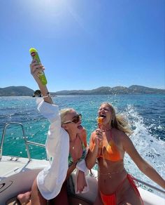 two women in bikinis on a boat with a bottle of beer and an ice cream cone