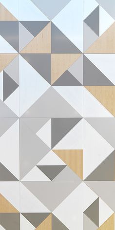 a white and grey wall with many different shapes on it's sides, including triangles