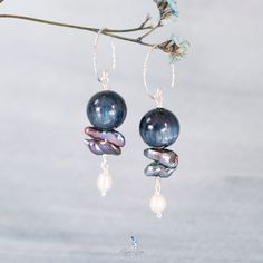 These unique Kyanite bead natural stone dangle drop earrings feature a beautiful 12 mm Kyanite stone bead, two irregular long blue pearls and a freshwater rice pearl dangle drop at the end. The ear wires are made from solid 925 sterling silver with texture diamond cut to maximum light refection. Add these unique Kyanite bead and pearls drop earrings to your everyday gemstone jewelry collection or as a gift for your loved one. Materials: 925 sterling silver, Kyanite, freshwater blue pearls, rice pearlsDimensions: 2 x 0.47 in Jewelry Care: See more information about how to care for your jewelry here. Shipping Policy: Orders will be shipped within 1-3 business days. Economy shipping will take 7-14 days to arrive and standard shipping is 1- 4 days for U.S. orders. International shipping time i Natural Stone Dangle Pearl Earrings, Blue Pearl Earrings With Pearl Charm, Handmade Blue Pearl Earrings In Sterling Silver, Handmade Blue Sterling Silver Pearl Earrings, Sterling Silver Dangle Pearl Earrings With Natural Stones, Blue Pearl Drop Dangle Earrings, Blue Dangle Pearl Drop Earrings, Blue Teardrop Sterling Silver Pearl Earrings, Handmade Blue Pearl Earrings