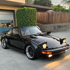 a black sports car parked in front of a house