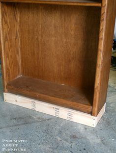 a wooden shelf sitting on top of a cement floor