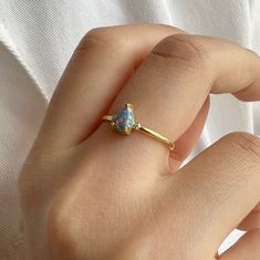 Blue opal ring is a new trend minimal product that you can use every day with a unique stone selected by ISEA Fine Jewelry. ➤ Ring Details * 14k / 18k Yellow Gold or Yellow Sterling Silver * Gold Color Options; 14K / 18k White, Yellow, Rose Gold * Sterling Silver Color Options; Yellow, Rose, White * Band Width: 2.30 mm * Thickness: 1.80 mm ➤ Gem Details * Gemstone 1 : Opal * Gem color: Blue * Gem width: 4 millimeter * Gem length: 6 millimeter * Cut Type: Pear * Gemstone 2 : Diamond * Diamond Carat: 0.05 * 2 * Cut Type: Round * Ready to Ship 3-5 Business Days 💍 ISEA Jewels' pieces are handcrafted by 10-15 years of experienced craftsmen and made to order in a very short time. 🎁 All pieces come in a quality and hygienic suede gift box enclosed in a pouch. 🌎 Our products arrive worldwide wi Minimalist Opal Birthstone Promise Ring, Minimalist Opal Rings With Gemstone, Modern Yellow Gold Opal Ring Gift, Modern Opal Ring For Anniversary, Fine Jewelry Moonstone Pear-shaped Ring Gift, Fine Jewelry Gift Moonstone Pear-shaped Ring, Fine Jewelry Gift: Pear-shaped Moonstone Ring, Minimalist Opal Rings With Birthstone, Minimalist Opal Ring With Birthstone