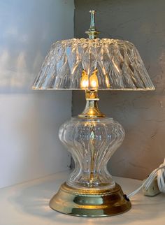 a glass table lamp sitting on top of a white counter