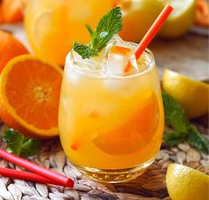 two glasses filled with lemonade and garnish on top of a woven table cloth