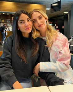 two women sitting next to each other at a table