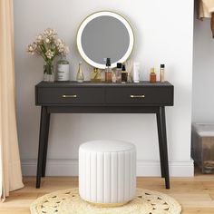 a vanity with a mirror, stool and flowers on the floor in front of it