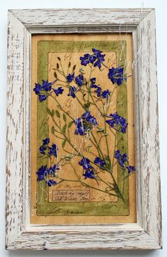 a painting with blue flowers in a white frame